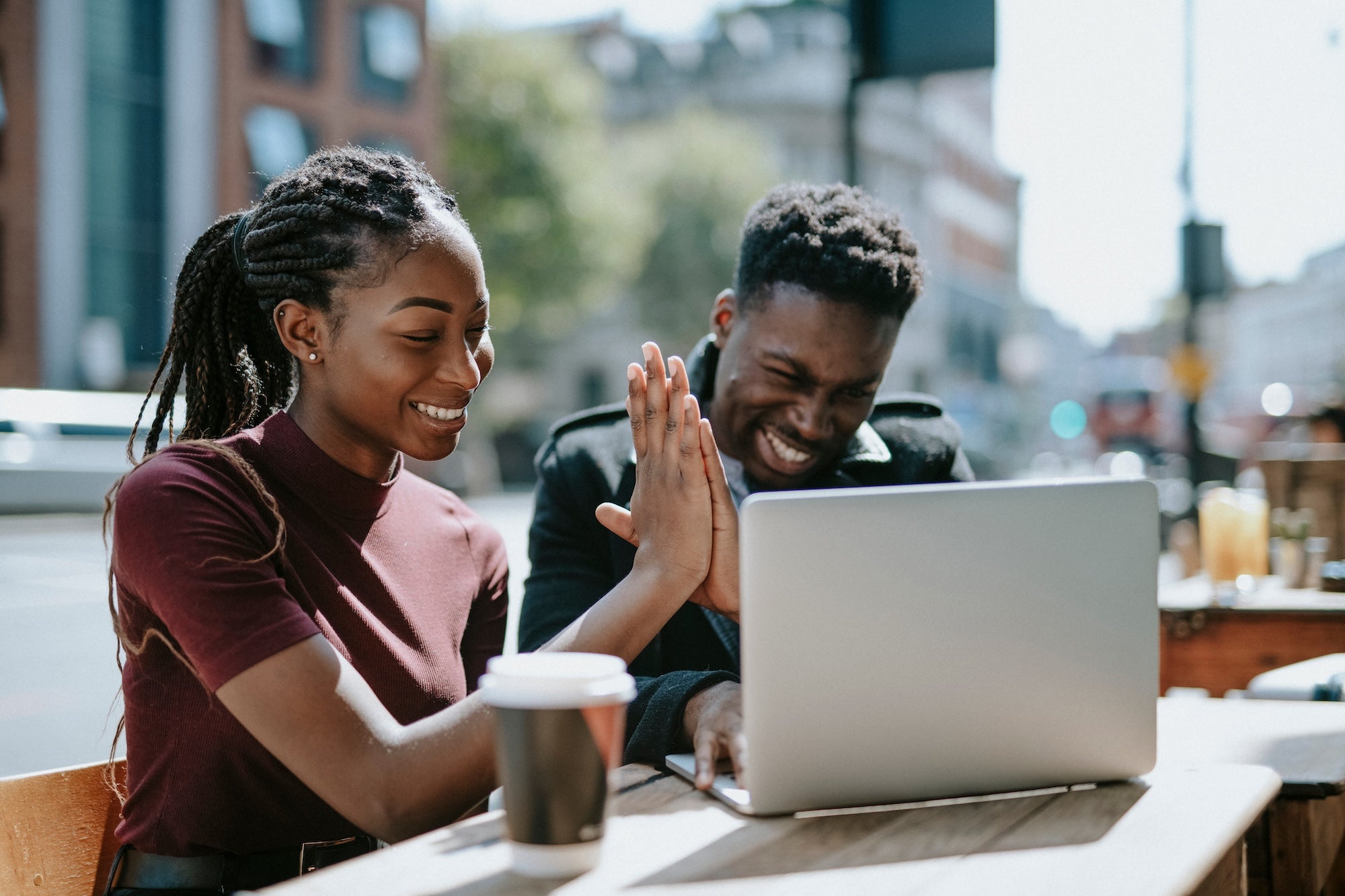 Couple high-fiving over computer